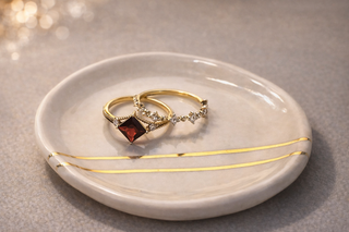 Princess Cut Garnet Ring with Diamond Accents on a porcelain plate with a diamond ring accent