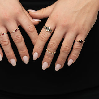 Close-up of hands with rings on a plain background