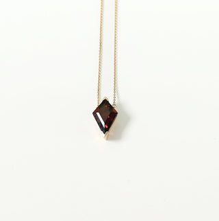 Minimalist necklace with a diamond pendant on a white background